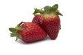 Three whole strawberries with their green leaves Royalty Free Stock Photo