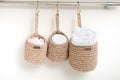 three wicker mini baskets hanging on a wall. toiletry storage in bathroom. eco natural jute hand made basket. cozy