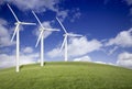 Three Wind Turbines Over Grass Field and Blue Sky