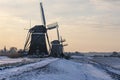 The three windmills in a row during sunrise on a cold winter morning with a snowy landscape at the three windmills in Leidschendam Royalty Free Stock Photo