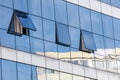Three windows on a building with a reflection of the building in the glass Royalty Free Stock Photo