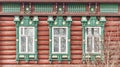 Three windows with carved wooden architraves on facade of 19th century log house , Russia Royalty Free Stock Photo