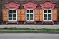 Three windows with the wooden carved architrave in the old wooden house in the old Russian town.