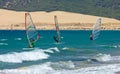 Three windsurfers on sandy Tarifa beach in southern Spain