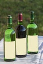 Three wine bottles - red and white standing on white mat Royalty Free Stock Photo