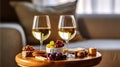 Three wineglasses of vintage chardonnay with delicious appetizers. white wine, italian breadsticks, figs and grapes. Interior