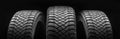 three winter studded tires on a black background are new. safe driving in winter in icy conditions