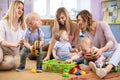 Three woman friends with toddlers playing on the floor in sitting room Royalty Free Stock Photo