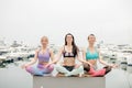 Three woman have meditation on yoga class, outdoor on marine pier. Royalty Free Stock Photo