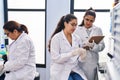 Three woman scientists holding sample write on checklist at laboratory