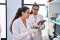 Three woman scientists holding sample write on checklist at laboratory