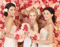 Three women with background full of roses Royalty Free Stock Photo