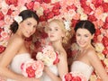 Three women with background full of roses Royalty Free Stock Photo