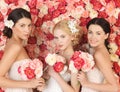 Three women with background full of roses Royalty Free Stock Photo