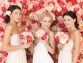 Three women with background full of roses Royalty Free Stock Photo