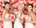 Three women with background full of roses Royalty Free Stock Photo