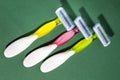 Three women colorful razors with selective focus on a green background. Royalty Free Stock Photo