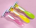 Three women colorful razors with selective focus on a pink background. Royalty Free Stock Photo