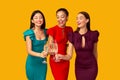 Three Women In Dresses Clinking Champagne Glasses Celebrating, Studio Shot