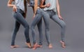 Three women in good form of pop in the legends of Push-Up on a gray background, fashionable advertising advertising space for text Royalty Free Stock Photo