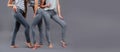 Three women in good form of pop in the legends of Push-Up on a gray background, fashionable advertising advertising space for text Royalty Free Stock Photo