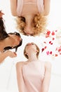 Three women having fun. Close-up portrait from below in flying petals. Elegant beige wedding Royalty Free Stock Photo