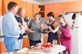 Women opposing men in kitchen