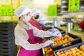 Three women in masks sorting peaches Royalty Free Stock Photo