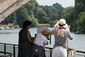 Three women painting a river scene