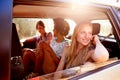 Three Women Sitting In Rear Seat Of Car On Road Trip