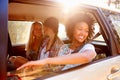 Three Women Sitting In Rear Seat Of Car On Road Trip