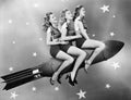 Three women sitting on a rocket