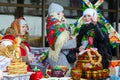 Three women are at table with pancakes and painted utensils during Shrovetide festivities