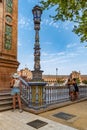 Seville SPAIN - August 9, 2022 - Three female tourists from the back admiring Plaza de EspaÃÂ±a next to colorful ceramic balustrade