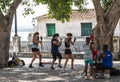 Three women and two children are learning how to box outside down by the water under a tree in Havana