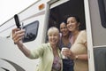 Three women using camera phone in motor home