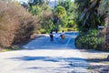 Three women walking down a smooth paved walking path in the garden with lush green trees and plants along the path Royalty Free Stock Photo