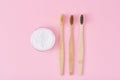 Three wooden bamboo toothbrushes and baking soda powder in glass jar on a pink background.  Teeth health and keep mouth concept Royalty Free Stock Photo