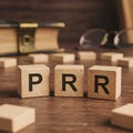 Three wooden blocks displaying the letters PRR on a wooden surface Royalty Free Stock Photo