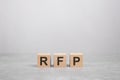 three wooden blocks with the letters RFP on the gray table. business concept