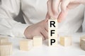 three wooden blocks with the letters RFP on the bright gray table. business concept. RFP - short for Request For Proposal