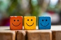 Three wooden blocks with smiling faces on them. Generative AI Royalty Free Stock Photo