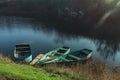 Three wooden boats peacefully resting on an autumn river at the Royalty Free Stock Photo