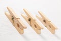 Three wooden clothespins with a metal spring on the background of a white wooden table. close-up Royalty Free Stock Photo