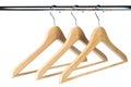 Three wooden coat / clothes hangers on a clothes rail Royalty Free Stock Photo