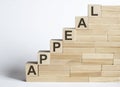 Three wooden cubes with letters APPEAL on white table