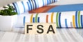 Three wooden cubes with letters FSA , on the white table with charts Royalty Free Stock Photo