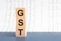 Three wooden cubes with letters GST - short for Goods and Services Tax, concept
