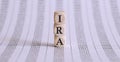 Three wooden cubes with letters IRA , on chart, business