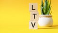 LTV - lifetime value - concept with wooden blocks on table, yellow background Royalty Free Stock Photo